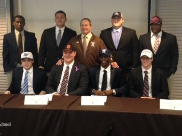 Coach Frank Lenti joined nine Mount Carmel Seniors who signed national letters of intent: (top left to right: Jaquan Bunytn, Devon Hickman, Lenti, Jack White, DeAndre Greer. Bottom: Colin Knusta, Andrejas Duerig, Marquise Peggs, Troy Weissenhofer)