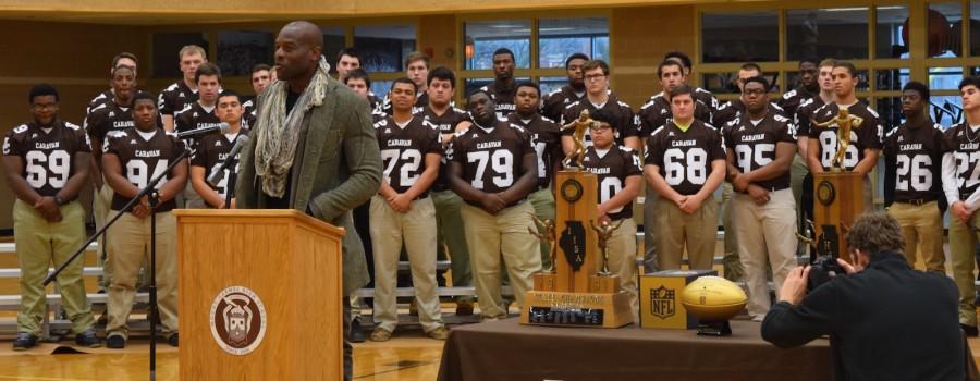 Simeon Rice (92) addressed the Mount Carmel student body, including the 2015 Caravan football team, before presenting the golden football to the school that prepared him for his journey to the NFL.