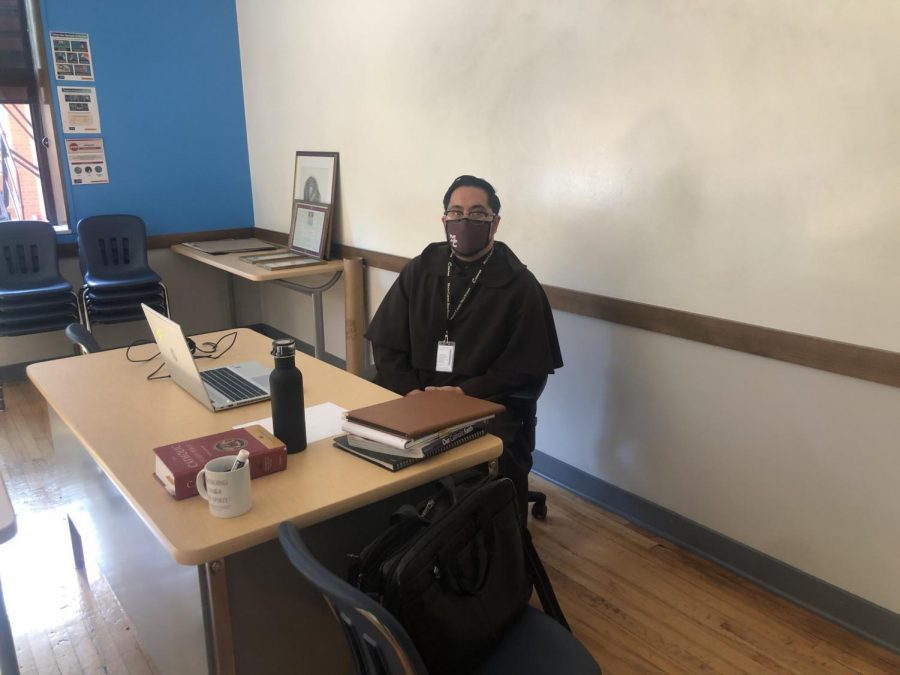 Brother Ryan, a new member of the Theology Department, prepares for class on October 2 in Room 111. sitting in his classroom. 