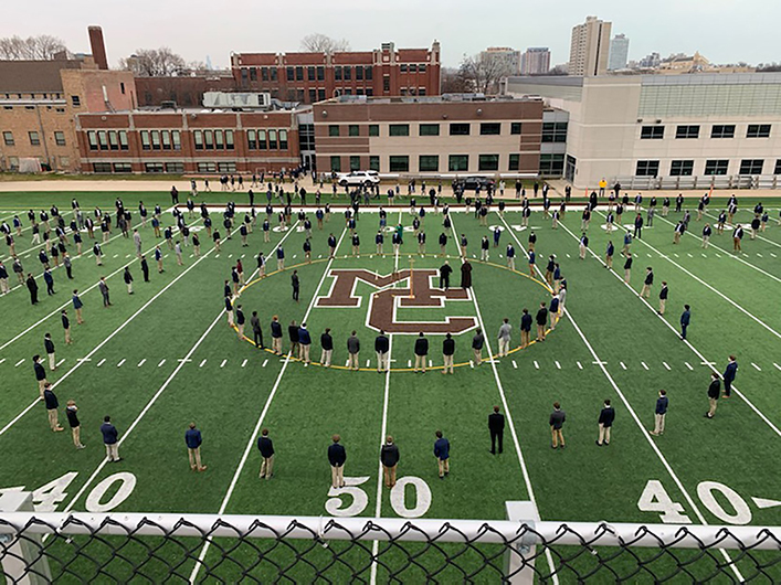 Students gather as a school but remain six feet apart. Together but apart.