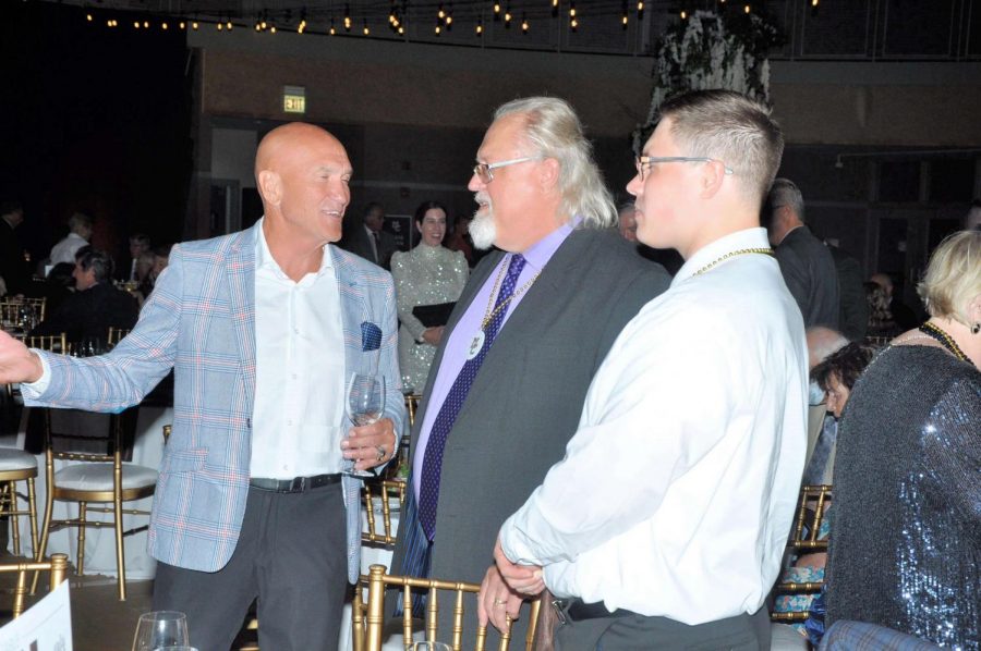 The two Mr. Novickases (center, right), current teachers at MC, speak with an alum at the 2021 Gala.