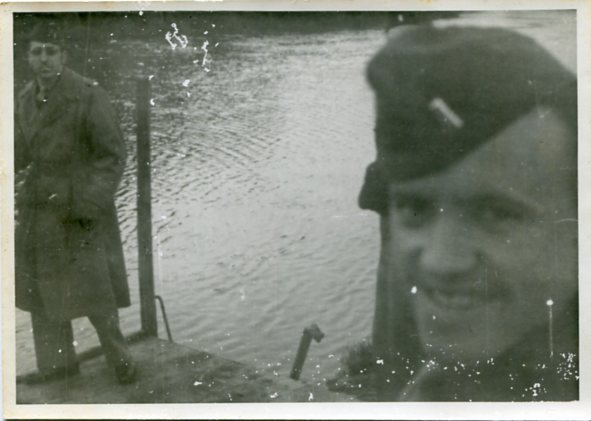 Photograph of U.S. army Lt. Robert J. Perry (left) while he stands near an unidentified soldier standing on a dock along a body of water in Europe during WWII (undated) [Photograph taken or collected by Pleasants  during his service in WWII]