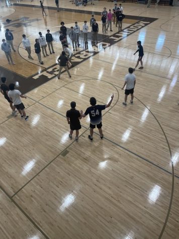 Students play in an January 31, 2022 intramural basketball game while their fellow teammates watch from the sidelines. 