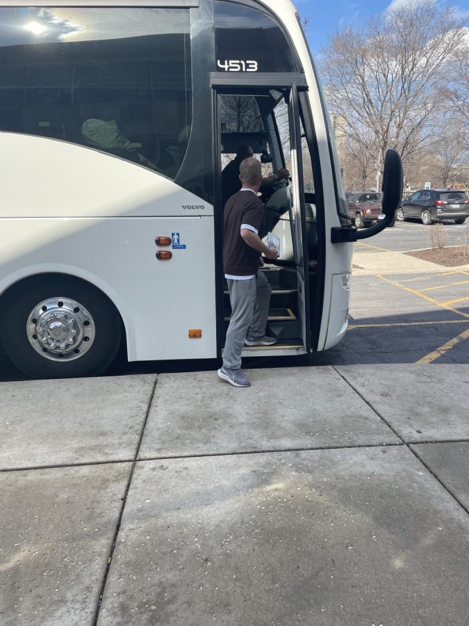 Head Coach Brian Hurry boarding the coach bus full of baseball players getting ready to go to play in the Metro East Kickoff Classic. 