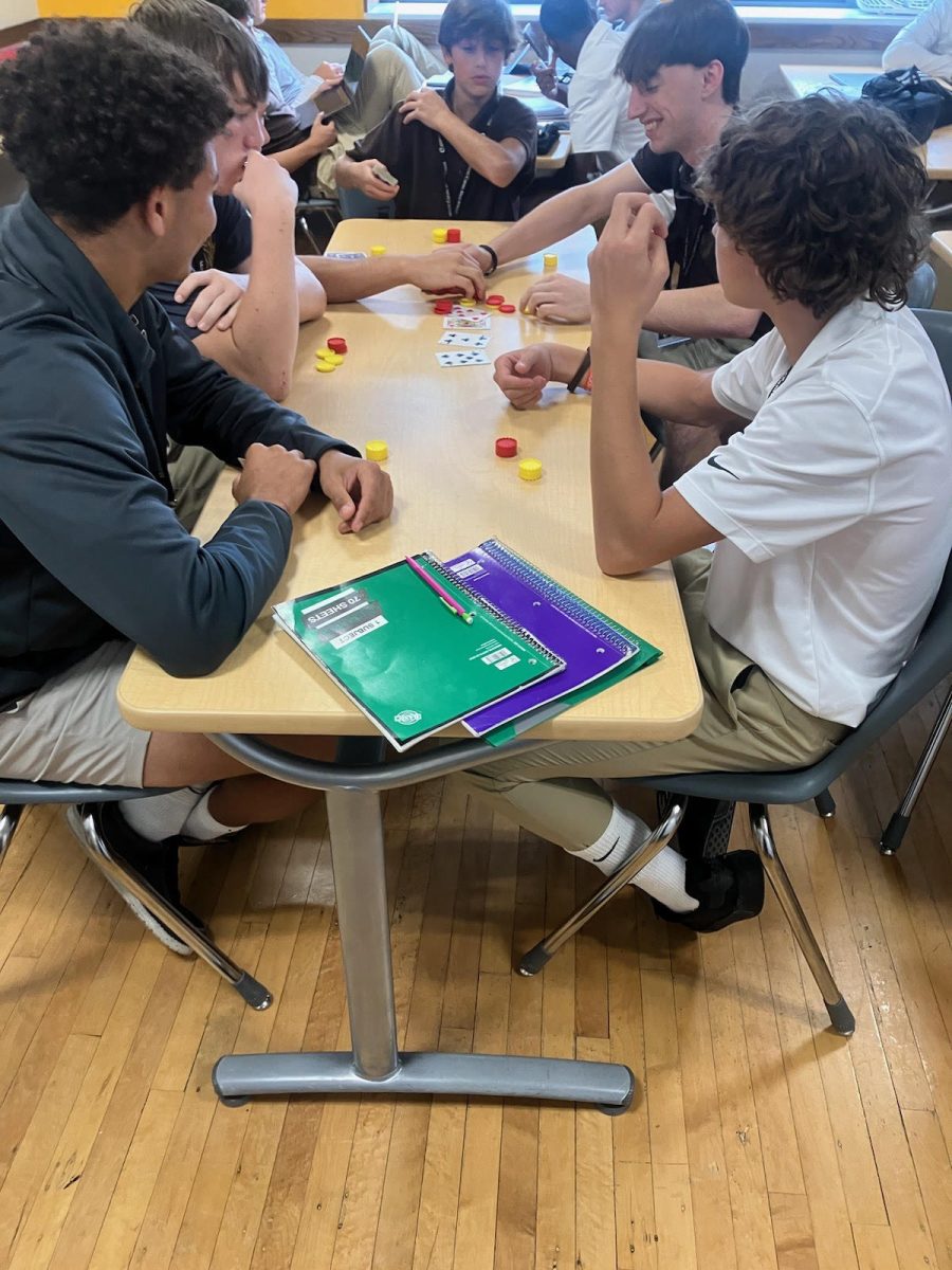 Juniors and seniors in Mr. Scheuring’s Studium teach freshman poker with Connect 4 chips. 

