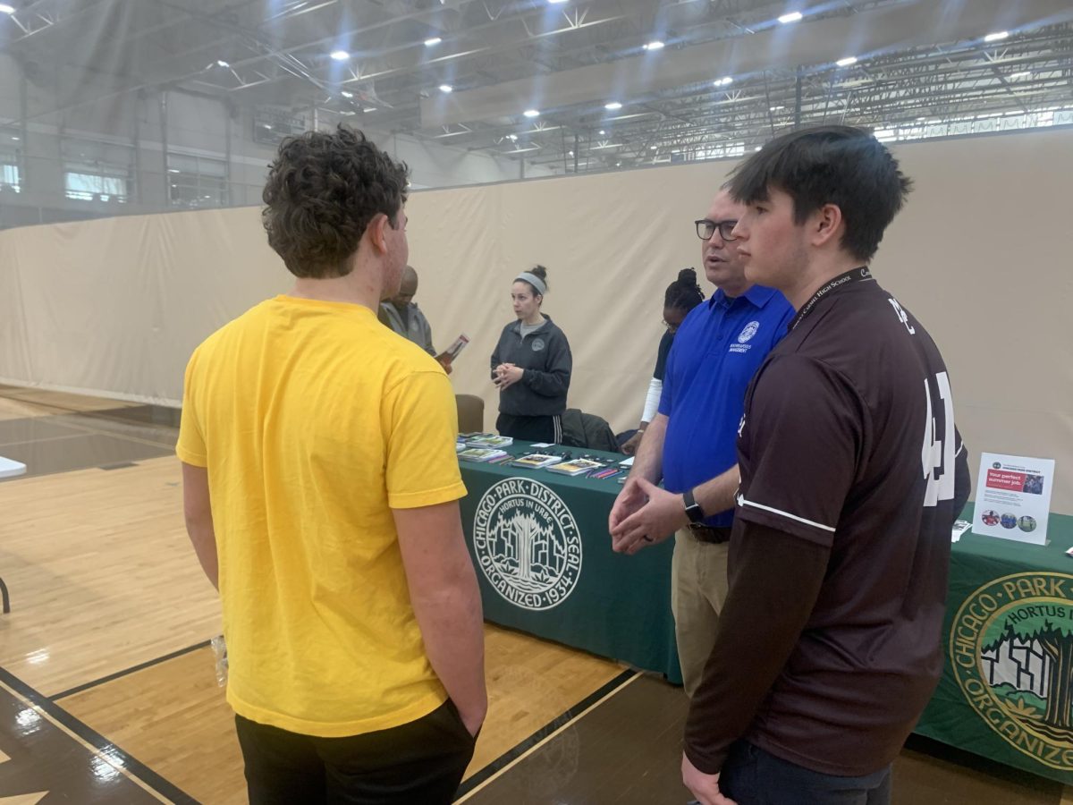 Sophomores Stephen Winkler (left) and Will Walsh (right) talk with MC alum Andrew Walsh ‘97 (center) of the Chicago Park District. (Jack Breakey)
