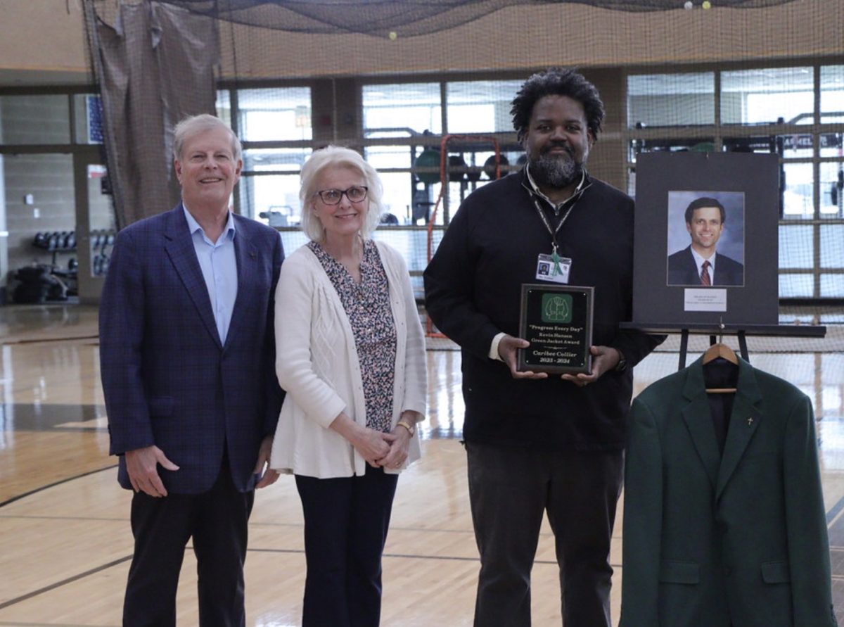 Along with the parents of Mr. Kevin Hansen, for whom the award honors, Mr. Caribee Collier stands next to the well-known green jacket after winning. 
