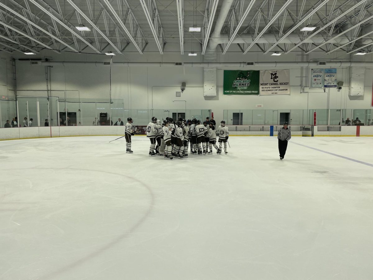 The hockey team embraces after their opening win against Crown Point High School. 
