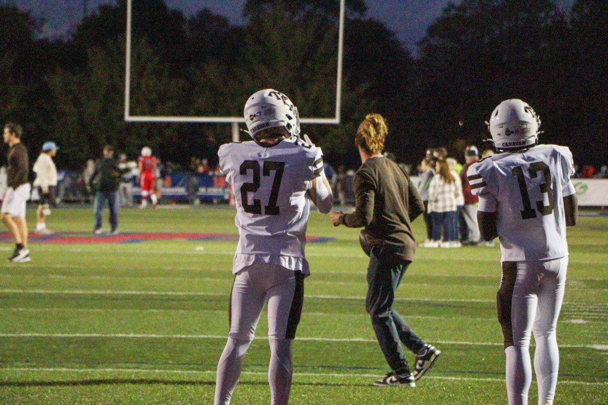 Zander Gorman, wearing number 27, surveys the field and puts on his gloves during warmups for the week two St. Rita football game.
