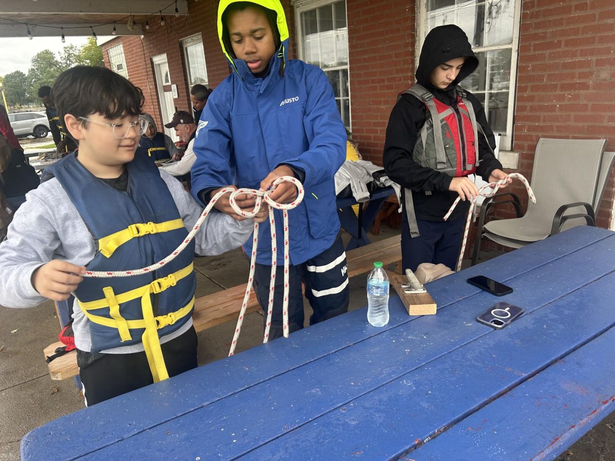 Timmy Carter '28 (center) teaches William Kinsey '28 (left) and Kenny Takruri '26 a cleat hitch knot. Learning various sailing knots is also part of being a sailor at MC.