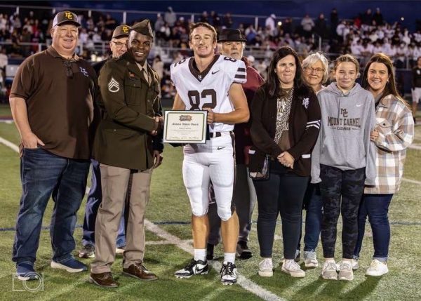 MC senior Marty Mann holds up his award nomination with his family.