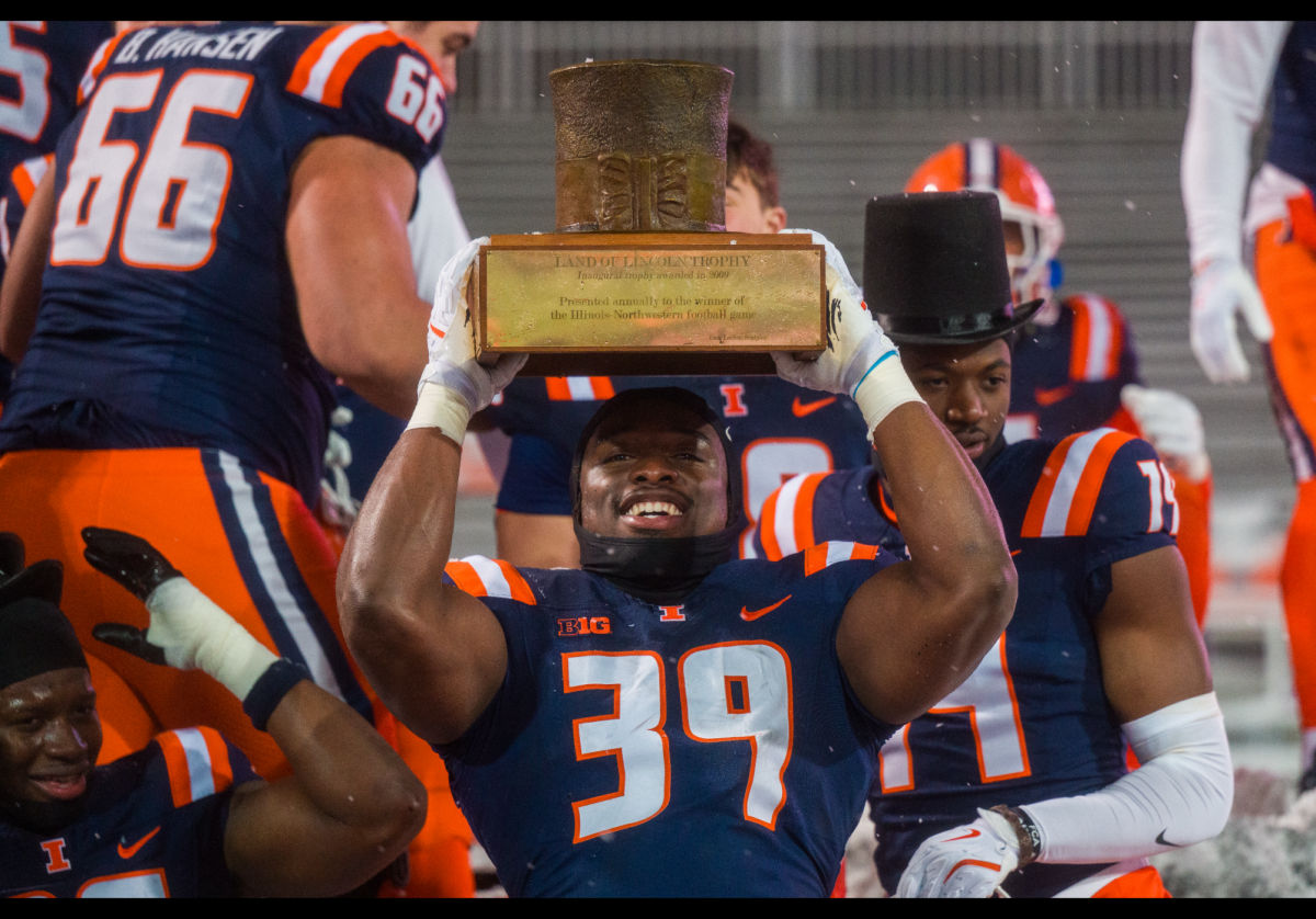 Mr. Kenna Odeluga holding the Land of Lincoln trophy above his head
